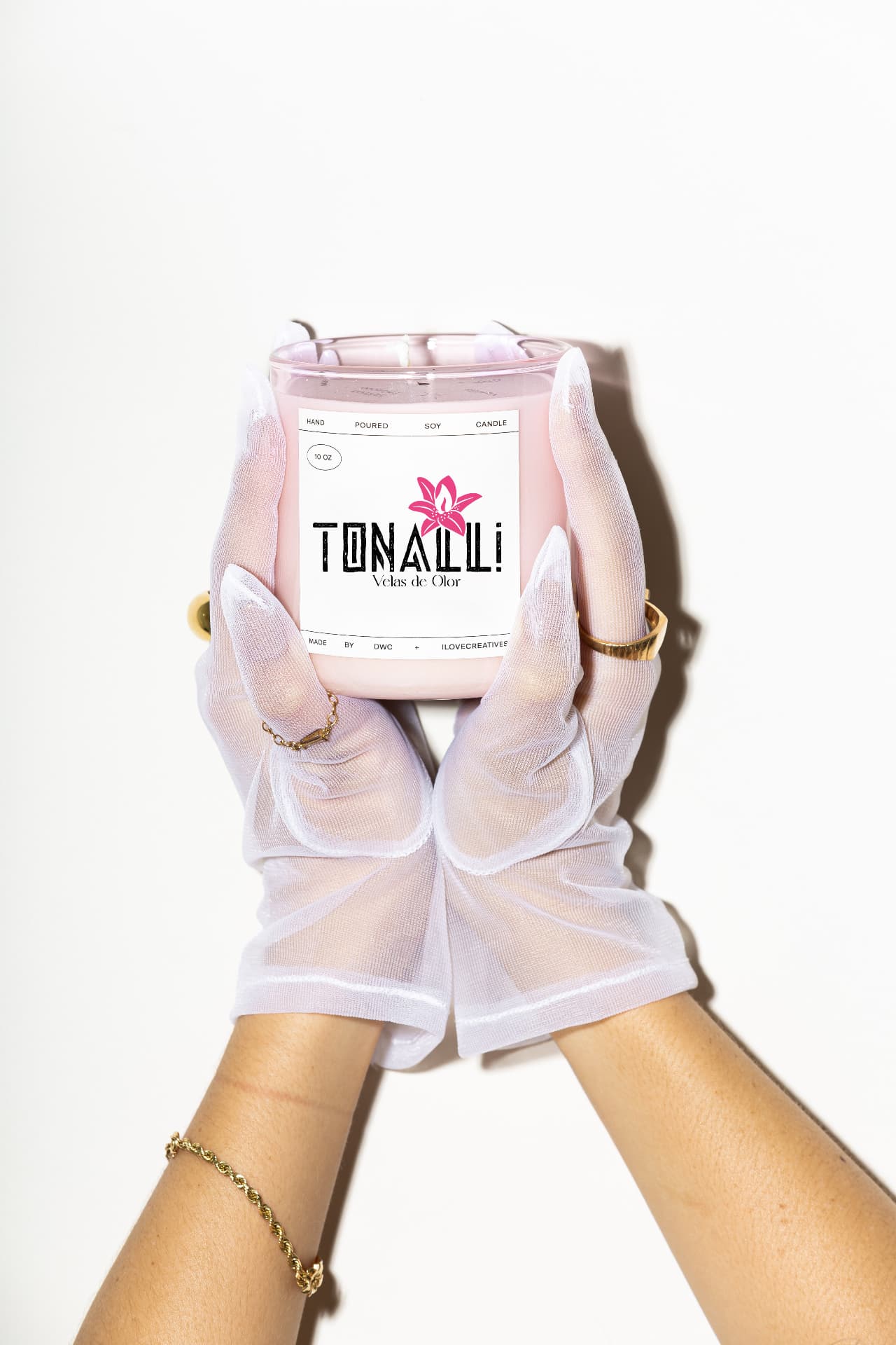 Tonalli hand-poured soy candle held in sheer gloved hands against a white backdrop